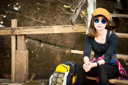 Tourist young woman wearing hat enjoying sitting on the stairs mountain.の写真素材