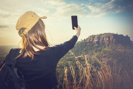 Backpackers or Hikers  Tourists Female enjoying take a photo in nature.の写真素材