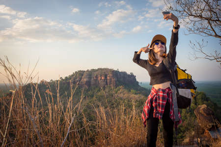 Backpackers or Hikers  Tourists Female enjoying take a photo in nature.の写真素材