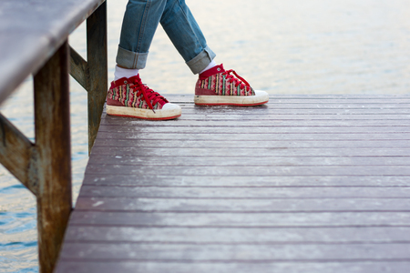 The girl's feet are sitting on the river.の写真素材