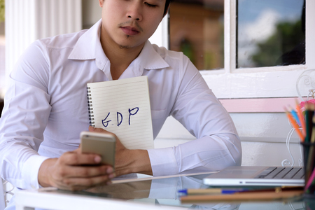 GDP words on the book with businessman holding a notebook.の写真素材