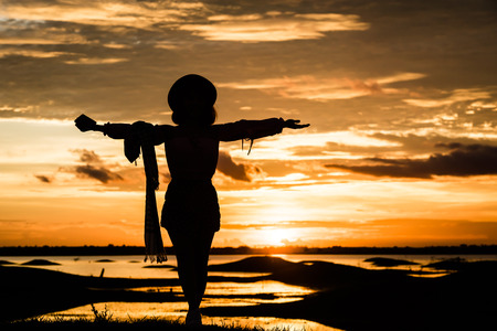 Silhouette Relax and freetime women on the hill and river over orange sunset background.の写真素材