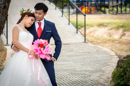 Young men and young women Couple together standing on the cement floor. Over Bridge in the background.の写真素材