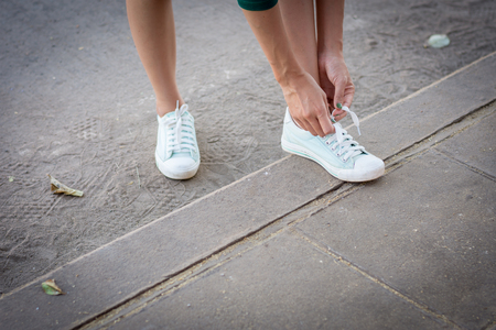 The girl's hand is tied on a shoelace.の写真素材