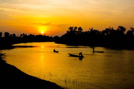 fisherman silhouette at moonnoi in thailandの写真素材