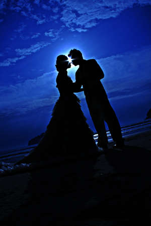 romantic young couple sunset silhouette on beach. honeymoon