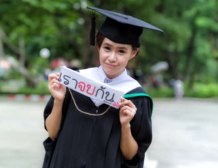 Graduation asian girls with congratulation in Thai wordingの写真素材