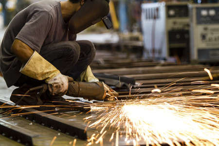 Electric wheel grinding on steel structure in factory の写真素材