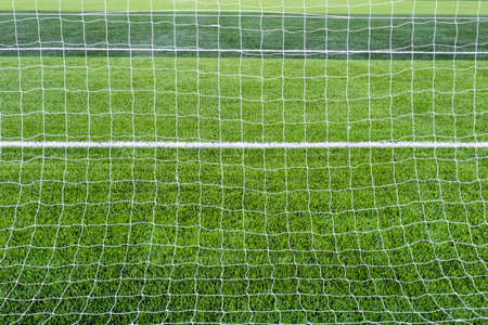 Goal net with green grass field  の写真素材