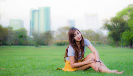 Woman smiling happy sitting in parkの写真素材