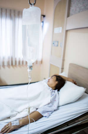 Woman patient in hospital bed の写真素材