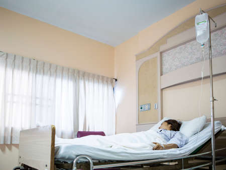 Woman patient in hospital bed の写真素材