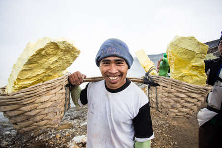 IJEN VOLCANO, INDONESIA - FEB 15 Worker carries sulfur inside crater on Febuary 15, 2014 in Ijen Volcano, Indonesia  He carries the load of around 70kg to the top of the crater and then 3km down  のeditorial素材