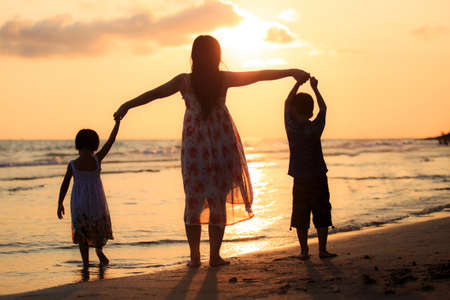 Mother with her daughter and son on the beachの写真素材