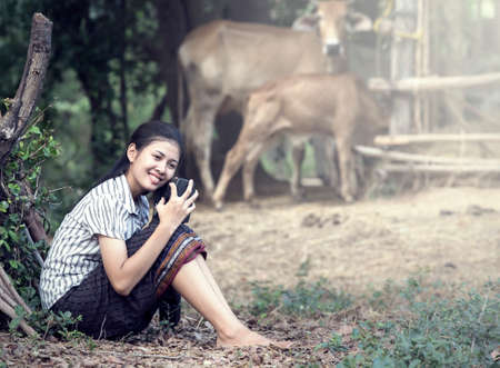 Thai Young Woman Holding Radio in farmの写真素材