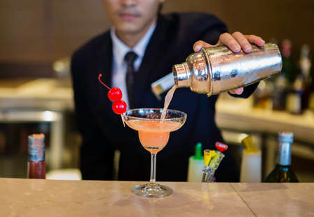 Bartender is making cocktail at bar counterの写真素材