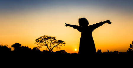 Silhouette freedom a Little girl at sunsetの写真素材