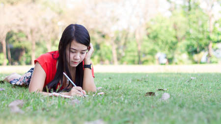 Beautiful young woman with note at outdoorの写真素材