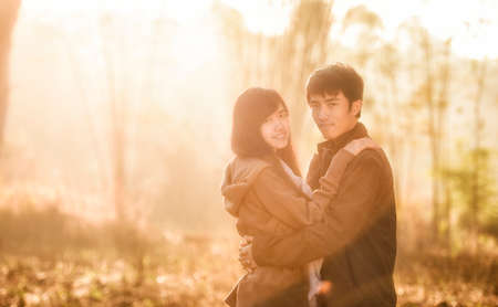 Happy couple having great time together - photographed at sunrise against sunの写真素材