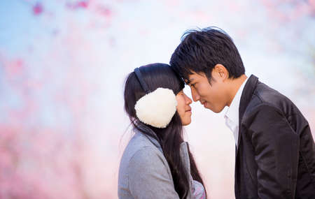 Young couple in love outdoor. They are smiling and looking at each other.の写真素材