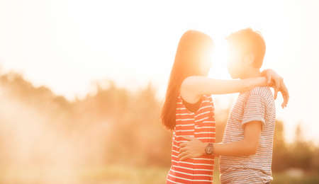 Young couple in love in the autumn park in the sunsetの写真素材