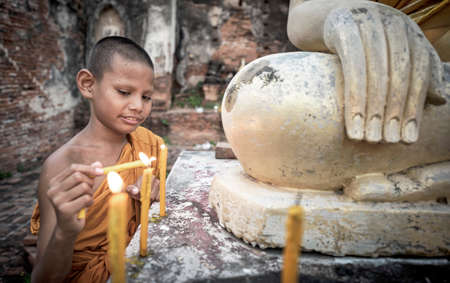 Novice Monk fire candles to the Buddhaのeditorial素材