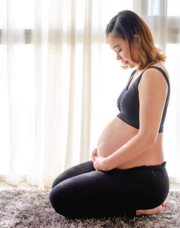 Pregnant woman touching her belly with handsの写真素材