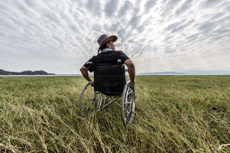 Man on a wheelchair relaxing in a park