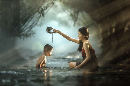 Sister and brother bathing in cascade, Thailandの写真素材