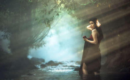 Asian woman in cascade, Thailand