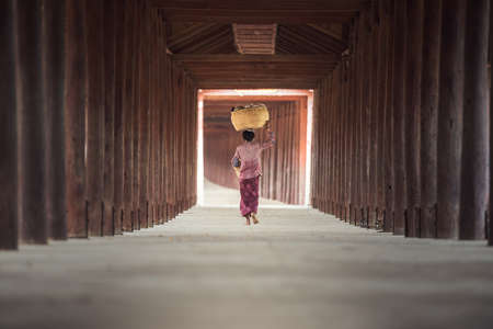 Burmese woman putting bamboo basket on head