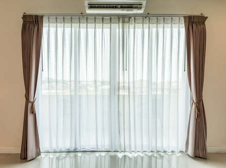 Light shines through white curtains in roomの写真素材