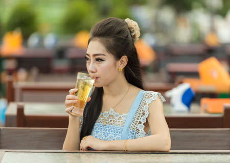 Woman drinking beer on cafe. Beautiful young asianの写真素材