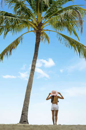 Woman on the beach with palm treeの写真素材