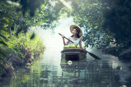 Young smiling agriculture woman worker on the boat and grapefruit harvest in gardenの写真素材