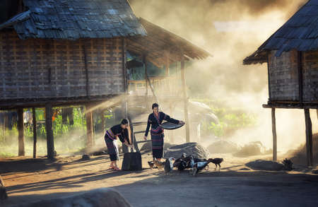 Asian girls feeding chickens at Laos countrysideの写真素材