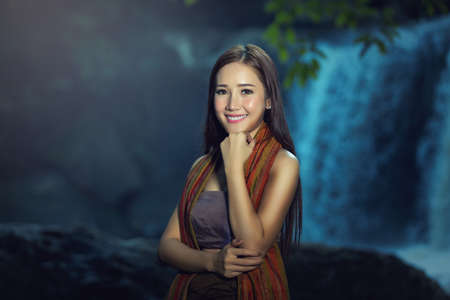 A portrait of a beautiful asian woman smiling brightly at the cameraの写真素材