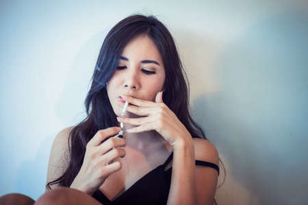 Beautiful sexy girl smoking a cigarette (vintage color)の写真素材