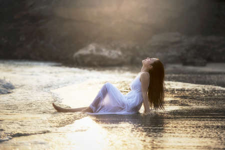 Smile Freedom and happiness woman on beach. She is enjoying serene ocean nature during travel holidays vacation outdoors. Asian beautyの写真素材