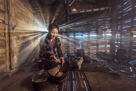 Young Asian woman cooking in the kitchen at Laos countrysideの写真素材