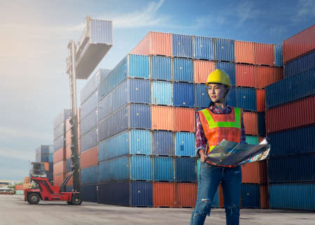 Women woker control loading Containers box from Cargo freight shipの写真素材