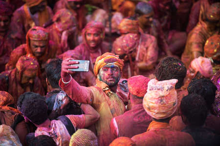 MATHURA, INDIA - Feburary 25,2018: Man takes selfie and have fun in colors during traditional holi festivalのeditorial素材
