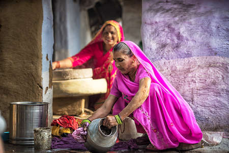 MATHURA, INDIA - Feburary 23,2018: Woman cleaning utensils at home, Mathuda, India.のeditorial素材