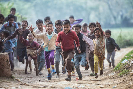 MATHURA, INDIA - Feburary 23,2018: Group of boisterous Indian children running for photograph in Agra, Uttar Pradesh, India.のeditorial素材