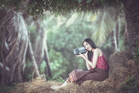 Woman listening to radio in countryside Thailand