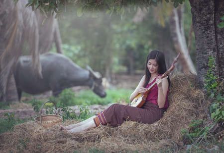 Thai woman playing folk song with Pin (Isan Guitar) traditional music instrumentの写真素材