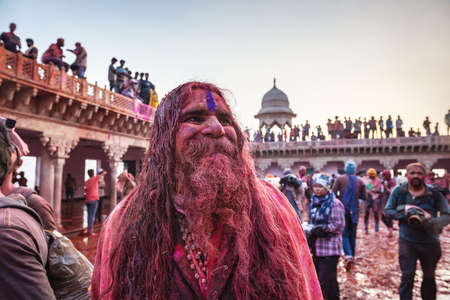 MATHURA, INDIA - Feburary 25,2018: Indian Hindu revellers smeared with colour dance during the Holi festival celebration in Mathura, Indiaのeditorial素材
