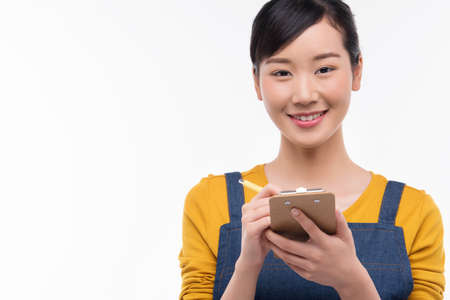 Young Asian woman take order from customer in coffee shop, cafe owner writing drink order at counter bar, Food and drink business concept, isolate backgroundの写真素材
