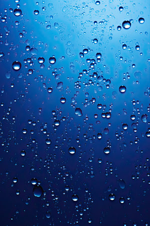 Dynamic deep blue background enhanced by sparkling water droplets and gradientsの素材