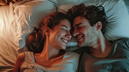 Happy couple is lying in bed together. Enjoying the company of each other.の素材